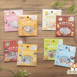May include: Eight square packages of decorative stickers featuring various animal and food illustrations. Each package displays Japanese text, a circular cutout showing the contents, and a count of 45 pieces. The colors include pink, orange, cream, brown, red, yellow, green, and light blue.
