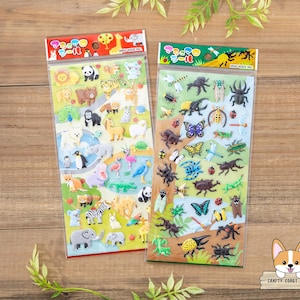 May include: Two packages of colorful animal and insect stickers. The animal stickers include a variety of animals such as elephants, penguins, zebras, and giraffes. The insect stickers include butterflies, beetles, and dragonflies.
