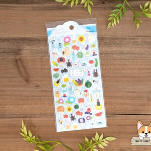 May include: A sheet of colorful stickers featuring Japanese summer festival themed illustrations. The stickers include images of fireworks, goldfish, food, and other summer festival elements. The stickers are on a white background with a blue border.