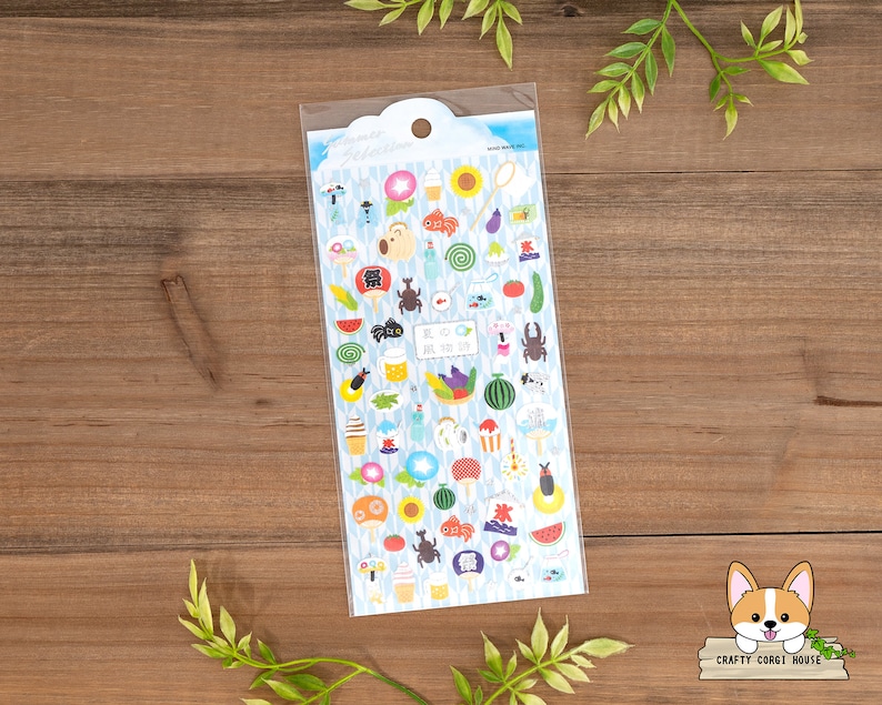 May include: A sheet of colorful stickers featuring Japanese summer festival themed illustrations. The stickers include images of fireworks, goldfish, food, and other summer festival elements. The stickers are on a white background with a blue border.