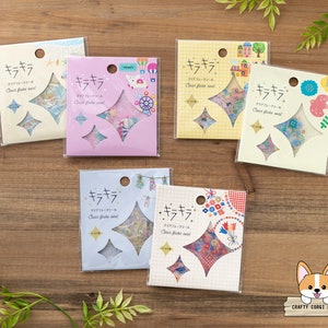 May include: Six packages of clear flake stickers with a variety of designs. Each package has a diamond-shaped window showing the stickers. The packages are labeled "キラキラ" which is Japanese for "sparkle".