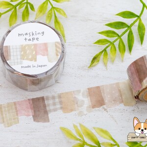 May include: A roll of masking tape with a decorative design. The tape features a variety of patterns in shades of brown, pink, and beige. The label reads "masking tape" and "made in Japan".