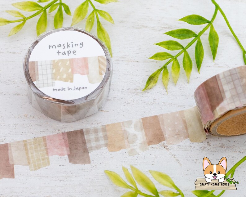 May include: A roll of masking tape with a decorative design. The tape features a variety of patterns in shades of brown, pink, and beige. The label reads "masking tape" and "made in Japan".