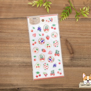 May include: A sheet of clear stickers with a variety of fruit designs, including cherries, strawberries, and blueberries. The stickers are on a white background with a brown border. The text "Cherry & Berry" is printed on the sheet.
