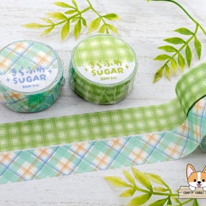 Pode incluir: Dois rolos de fita washi com padr&atilde;o verde e azul com o texto "きらふわす + SUGAR BGM TAC" e "きら、明 SUGAR+ BGM Inc" impresso nos rolos.