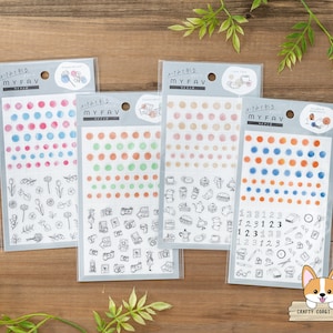 May include: Four sheets of colorful watercolor dot stickers with various designs. The stickers feature different colored dots, numbers, and illustrations of flowers, cameras, and teacups. The text on the sheets reads "MYFAV".