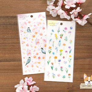 Op de afbeelding: Twee vellen stickerpapier met aquarel illustraties. Eén vel heeft een patroon van roze bloemen en kleine vogels. Het andere vel heeft een verscheidenheid aan kleurrijke bloemen. Beide vellen hebben de tekst "masking seal" en de naam van het ontwerp.