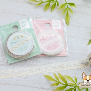 May include: Two rolls of washi tape with gold foil accents. The tape is 5mm wide and comes in a clear plastic package with a green and pink background. The packaging has the text "BGM" and "foil stamping" on it. The tape is on a white surface with a gold and white patterned washi tape.