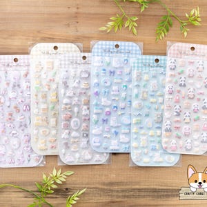 May include: Six sheets of colorful sticker paper with various cute animal and object designs. The stickers are in a milky pastel color scheme. The stickers are packaged in clear plastic sleeves.