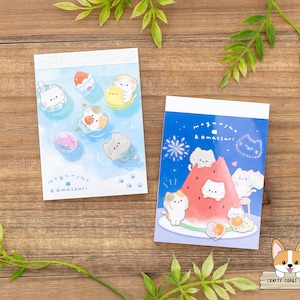 May include: Two small notepads with colorful illustrations of cartoon cats. One notepad features cats in water with ice cream, the other shows cats on a watermelon. The text "megunyan & omatsuri" is visible on both.