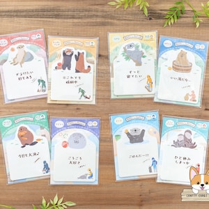 Puede incluir: Conjunto de diez pegatinas de animales ilustradas de colores con texto japonés. Las pegatinas presentan una variedad de animales, incluyendo una nutria marina, un mapache, un oso, un koala, un pingüino, una foca, un tejón, una ardilla, un gato y un perro. Las pegatinas son perfectas para añadir un toque de fantasía a tu agenda, diario o álbum de recortes.
