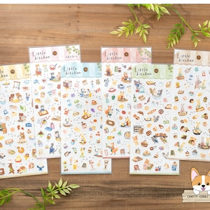 May include: Six sheets of stickers featuring illustrations of a kitchen theme. Each sheet has the text "Little Kitchen" and features various illustrations of food, animals, and kitchen items. The stickers are on a white background.