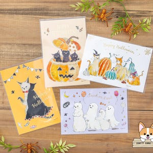 Puede incluir: Cuatro tarjetas de felicitación de Halloween con ilustraciones de gatos. Una tarjeta presenta gatos en una calabaza, otra muestra gatos con calabazas y una tercera tiene un gato con disfraz de vampiro. La cuarta tarjeta dice "Trick or treat!"