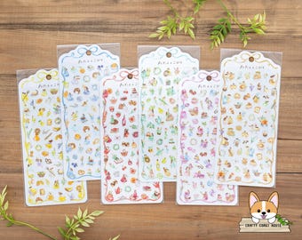 May include: Set of seven sheets of colorful patterned stickers featuring various illustrations of teacups, cakes, flowers, and other whimsical designs. The stickers are packaged in clear plastic sleeves and labeled with the Japanese text "サ イ ル ム ニ コ".