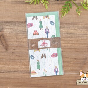 May include: A green and white envelope with a whimsical pattern of people, hats, and other objects. The envelope has the text "Letters & Envelopes 2" and "Totoro's Haystack" printed on it.