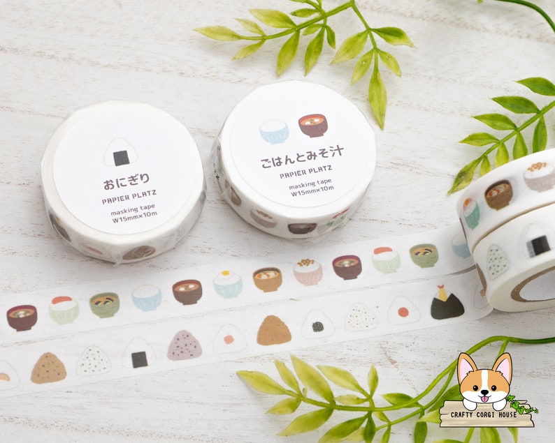 May include: Two rolls of white washi tape with Japanese characters and illustrations of bowls of rice and soup. The tape is 1.5 cm wide and 10 meters long.