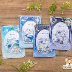 Puede incluir: Cuatro paquetes de pegatinas con texto e ilustraciones japonesas. Cada paquete presenta un tema diferente: océano, cielo, noche estrellada y magia. Las pegatinas están en un embalaje de plástico transparente con un borde decorativo.