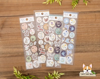 May include: Four sheets of clear sticker paper with various designs. Each sheet features a different theme: bunnies, squirrels, birds, and flowers. The stickers are printed with watercolor-like illustrations and are perfect for adding a touch of whimsy to planners, journals, and other craft projects.