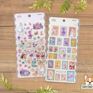 May include: Two packs of Alice in Wonderland stickers. One pack features various characters and the text "Alice in Wonderland". The other pack has framed images of characters. The stickers are on a white background with a scalloped edge.