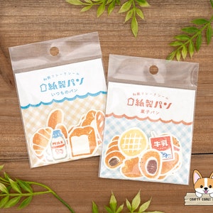 May include: Two packs of Japanese paper craft stickers featuring illustrations of bread, milk, and other bakery items. The stickers are labelled "Paper Bread" in Japanese.