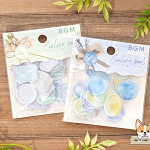 May include: Two packs of sealing wax stickers. The stickers are in the shape of wax seals and have a watercolor design. The stickers are labeled "BGM Drop Sticker Sealing Seal".