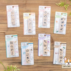 Peut inclure: Plusieurs tampons en bois avec des illustrations d'animaux et d'objets, emballés sur des cartes colorées. Les tampons sont disposés en rangée verticale, avec du texte japonais et des motifs de calendrier.