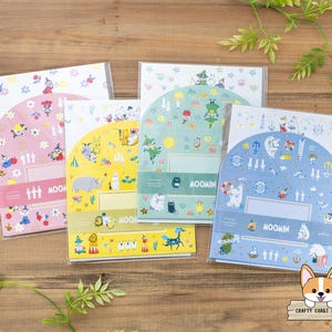 Peut inclure: Quatre ensembles de papeterie sur le thème des Moomins. Chaque ensemble présente un code couleur différent : rose, jaune, vert et bleu. Les ensembles sont décorés de personnages Moomin et d'autres illustrations. Chaque ensemble porte l'inscription "MOOMIN".
