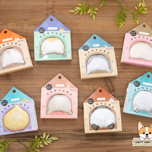 Puede incluir: Un conjunto de ocho notas adhesivas ilustradas y coloridas 'Puni Ketsu' que representan diferentes traseros de animales. Cada nota adhesiva está empaquetada en una pequeña caja con forma de casa con el texto 'Puni Ketsu' y '40 hojas' impreso en la parte delantera.
