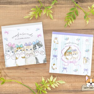 May include: Two sets of memo pads featuring a cute cat design. The top pad shows four kittens with pink, blue and green bows. The bottom pad features two kittens with pink bows. Both pads have the text "snufusand A cute little nickname" printed on them.