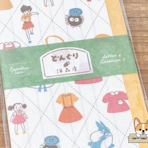 May include: A set of 4 letter paper and 2 envelopes with a white background and a repeating pattern of a blue and white character, a red and white dress, a yellow and red dress, a blue and black character, and a red and white dress. The paper and envelopes have a green border with the text "Ippitsu sen" and "どんぐり  雑貨店" in Japanese. The text "Letter 4 Envelope 2" is also on the green border.