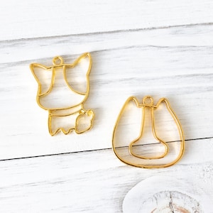 May include: Two gold metal frames for resin crafts. One frame is shaped like a dog and the other is shaped like a horseshoe.