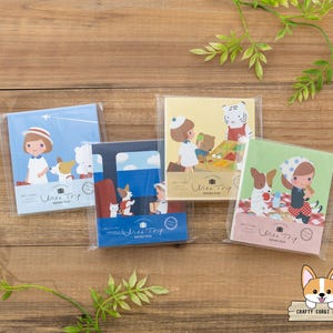 May include: Four memo pads in plastic packaging, each with a different illustration. The illustrations feature cartoon characters, animals, and travel themes. The pads are in shades of blue, yellow, and green, with the text "Wish Trip" on each.