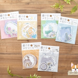 Puede incluir: Seis paquetes de pegatinas florales y de temática de casas, coloridas, etiquetadas como "書けるメモシール" (Pegatinas de notas escribibles) en japonés.