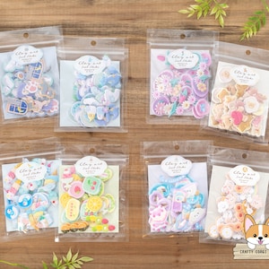 May include: Eight clear plastic bags each containing a sheet of colorful clay art stickers. The stickers feature various themes including animals, flowers, food, and abstract designs. The bags are labeled "Clay Art Self-Stick" with the theme of the stickers listed below.