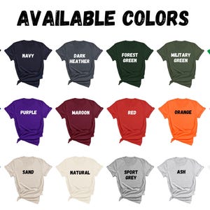Puede incluir: Una selecci&oacute;n de camisetas en varios colores, incluyendo negro, azul marino, gris oscuro jaspeado, verde bosque, verde militar, verde irland&eacute;s, azul real, morado, granate, rojo, naranja, rosa claro, azul claro, arena, natural, gris deportivo, ceniza y blanco. El texto "AVAILABLE COLORS" est&aacute; en la parte superior de la imagen.
