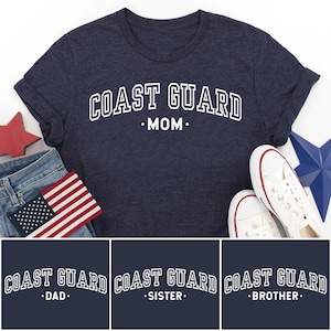 May include: Navy blue t-shirt with the text "COAST GUARD MOM" in white, along with a pair of white sneakers, a small American flag, and a red star. Additional shirts with "DAD", "SISTER", and "BROTHER" are also shown.