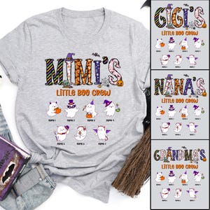 May include: A light gray t-shirt featuring the text "MIMI'S Little Boo Crew" with ghost illustrations. The design includes a witch hat, pumpkins, and bats. Additional designs for "GIGI'S", "NANA'S", and "GRANDMA'S" are also shown.