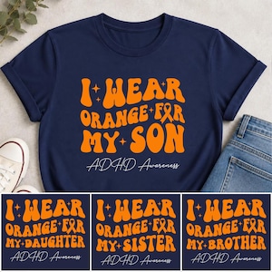 Peut inclure: Un t-shirt bleu marine avec un texte orange de style rétro indiquant I WEAR ORANGE FOR MY SON, accompagné d'une icône de ruban de sensibilisation et de petites étoiles. En dessous, ADHD Awareness est écrit en fine écriture blanche.