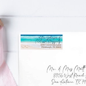 May include: A white envelope with a blue and white beach-themed address label. The address label says "Lifen Johnson & Melissa Huggerty, 1340 University Lane, Pittsburgh, PA 16801". The envelope is addressed to "Mr. & Mrs. Matt Smith, 8956 West Ranch Rd., San Antonio, TX 74988".