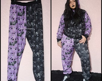 Pastel Goth Jogger Sweatpants, Kawaii Spooky Skeleton Bat Print Split Black & Pastel Purple, Cute Goth Jogger Pants with Pockets