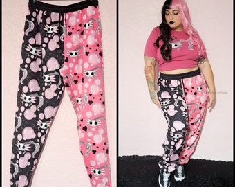 Pastel Goth Jogger Sweatpants, Kawaii Spooky Skeleton Axolotl Print Split Black & Pink, Cute Goth Jogger Pants with Pockets