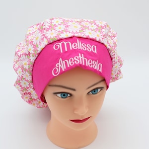 May include: Pink scrub hat with a white daisy print and the name "Melissa Anesthesia" embroidered on the front.