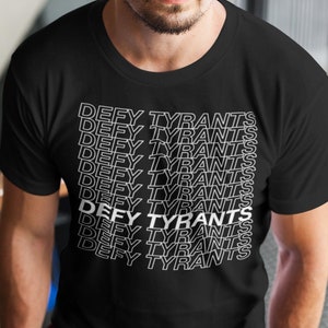 May include: A black t-shirt with the phrase "DEFY TYRANTS" repeated in white text.