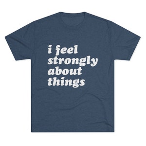 Puede incluir: Una camiseta azul marino con texto blanco que dice "i feel strongly about things".