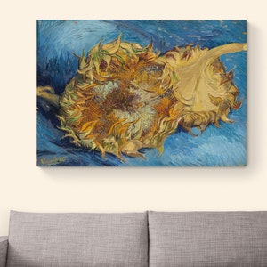 Op de afbeelding: Een schilderij van twee zonnebloemen, een naar de kijker gekeerd en de andere met de rug naar de kijker, tegen een blauwe achtergrond. De zonnebloemen zijn geschilderd in een levendig geel en bruin, met een textuurrijke penseelstreek stijl. Het schilderij is onderaan links gesigneerd met "Vincent".