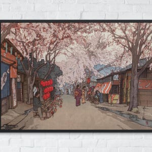 以下が含まれることがあります： 桜の季節の日本の街並みを描いた額装アートプリント。満開のピンク色の木々、伝統的な木造建築、赤い提灯、そして木々の下を歩く着物姿の人物が描かれた、細部まで描き込まれたイラストレーションです。