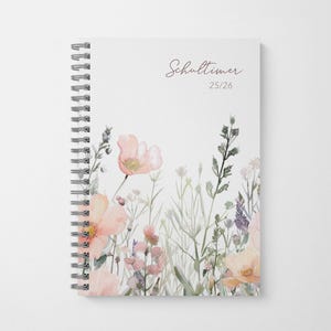 May include: A floral design notebook with a spiral binding. The cover displays a watercolour illustration of wildflowers in peach, pink, and purple hues. The text "Schultimer 25/26" is written in a script font. The notebook has a white background.