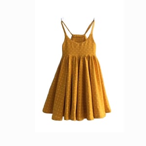 May include: A yellow sleeveless dress with white polka dots. The dress has a fitted bodice and a flowing skirt.