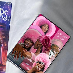 May include: A clear phone case featuring a collage of images with a pink theme. The images include people wearing pink fur hats, sunglasses, and accessories. The text "I'M JUST A GIRL" is visible on the case.