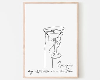 May include: A black and white line drawing of a hand holding a martini glass. The text "I prefer my espresso in a martini" is written below the glass.